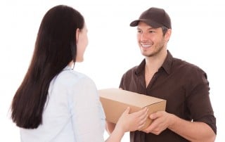 UPS Delivery Driver handing a package to a woman. Amazon recently had to pull a Teeth whitening product from it's warehouses