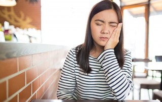 Young asian woman sitting at a table at a diner with a toothache & sensitivity. Maybe you have added more brushing or flossing into your daily routine. Perhaps you changed your toothpaste. No matter what you’ve done, nothing seems to be helping. At Durham in Hilton Head, we have some expert suggestions that can save you some time and pain.